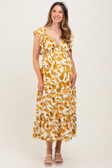 woman wearing a floral print yellow and white maternity dress with ruffle sleeves and a tiered skirt, showing her baby bump
