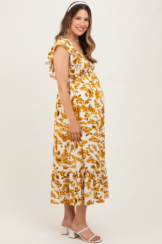woman wearing a yellow floral maternity dress with ruffled sleeves and a baby bump