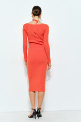 woman wearing a coral long sleeve ribbed midi dress with a tie back detail