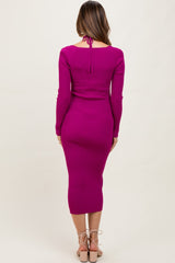 woman wearing a fuchsia long sleeve ribbed maternity dress with a tie back, showing a sleek silhouette