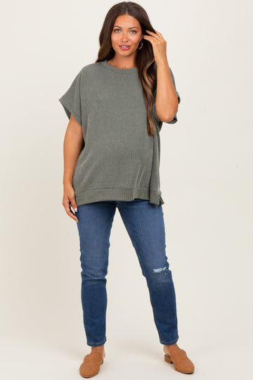 woman wearing a striped green maternity top with short sleeves and blue distressed jeans