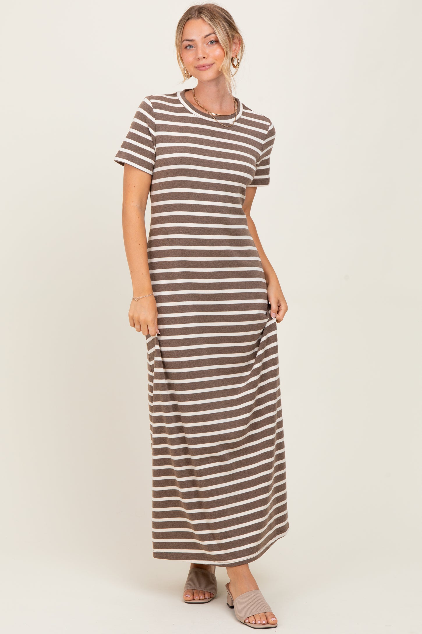 woman wearing a brown and white striped maxi dress with short sleeves and a relaxed fit