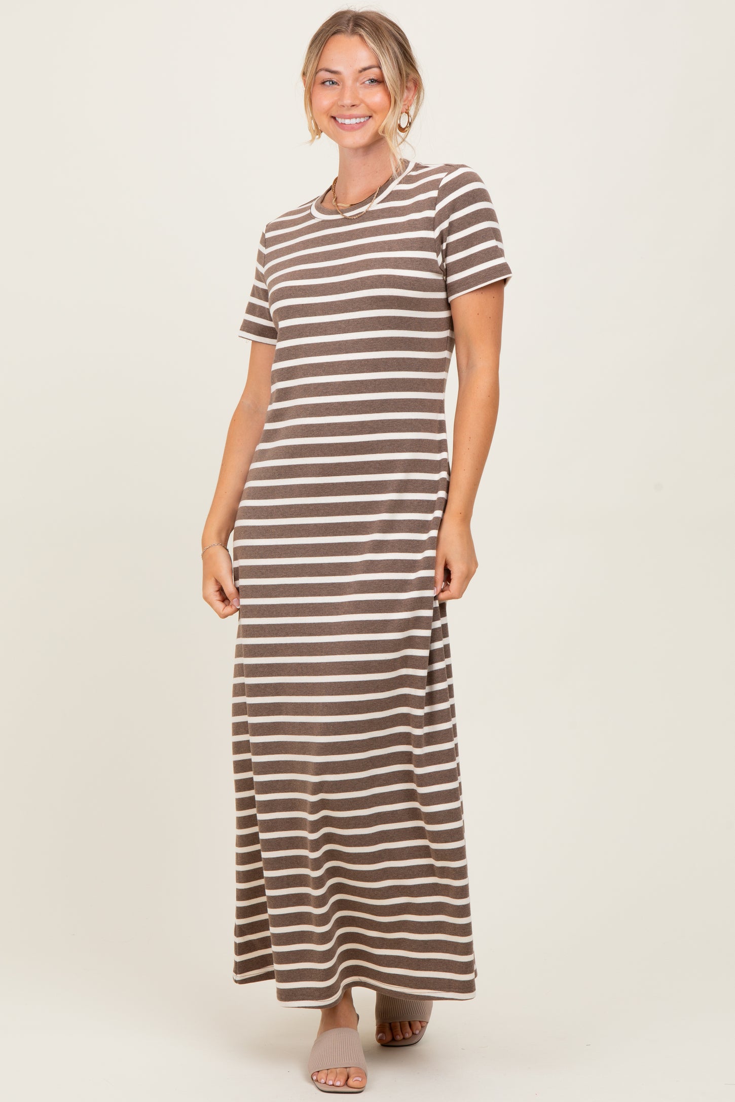 woman wearing a brown and beige striped maxi dress with short sleeves and a relaxed fit