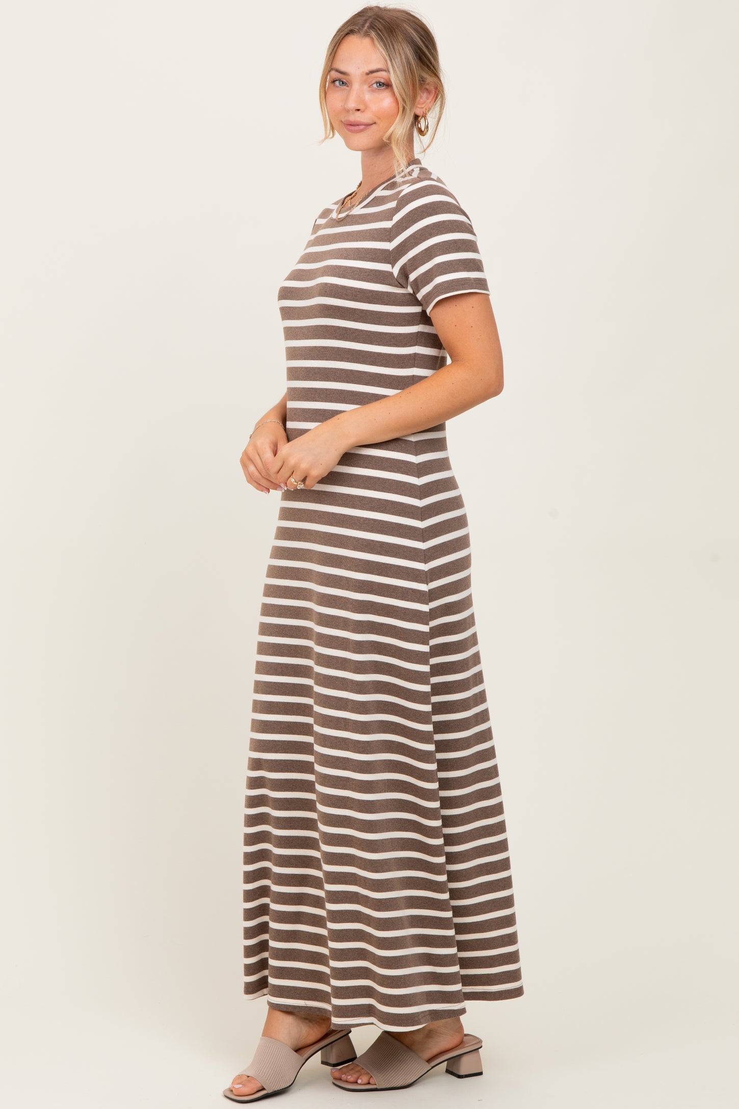 woman wearing a striped brown maxi dress with short sleeves and a fitted bodice