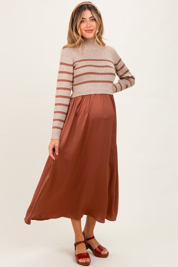 woman wearing a striped beige cropped sweater and a brown maternity maxi skirt, showcasing her baby bump