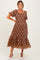 woman wearing a brown floral maternity dress with puff sleeves and a tiered skirt, showcasing a baby bump