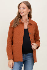 woman wearing a rust-colored maternity jacket with button closure and a front pocket over a black top
