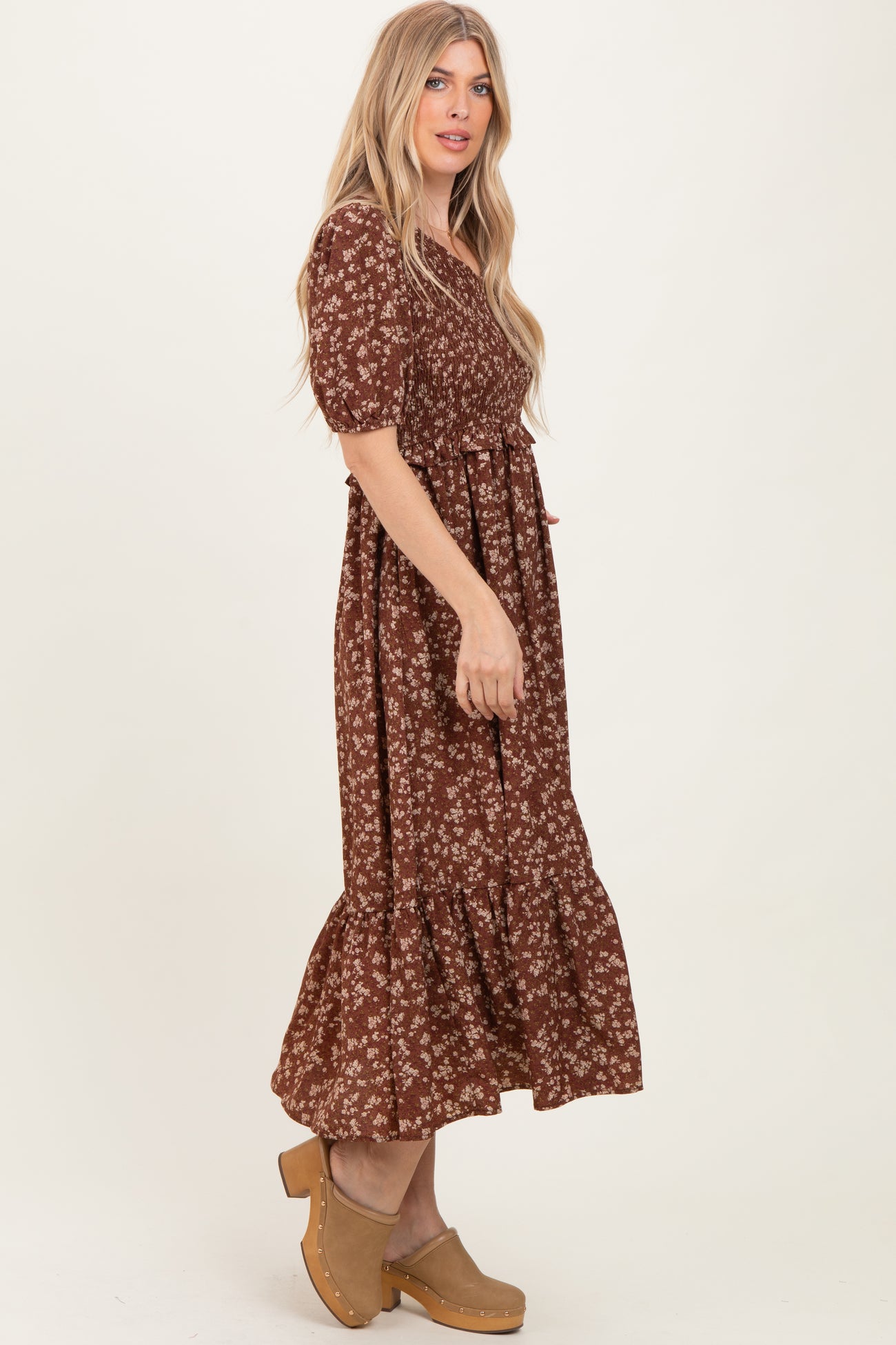 woman wearing a brown floral print maxi dress with puff sleeves and a ruffled hem