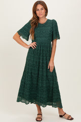 woman wearing a green lace maxi dress with short sleeves and a fitted bodice