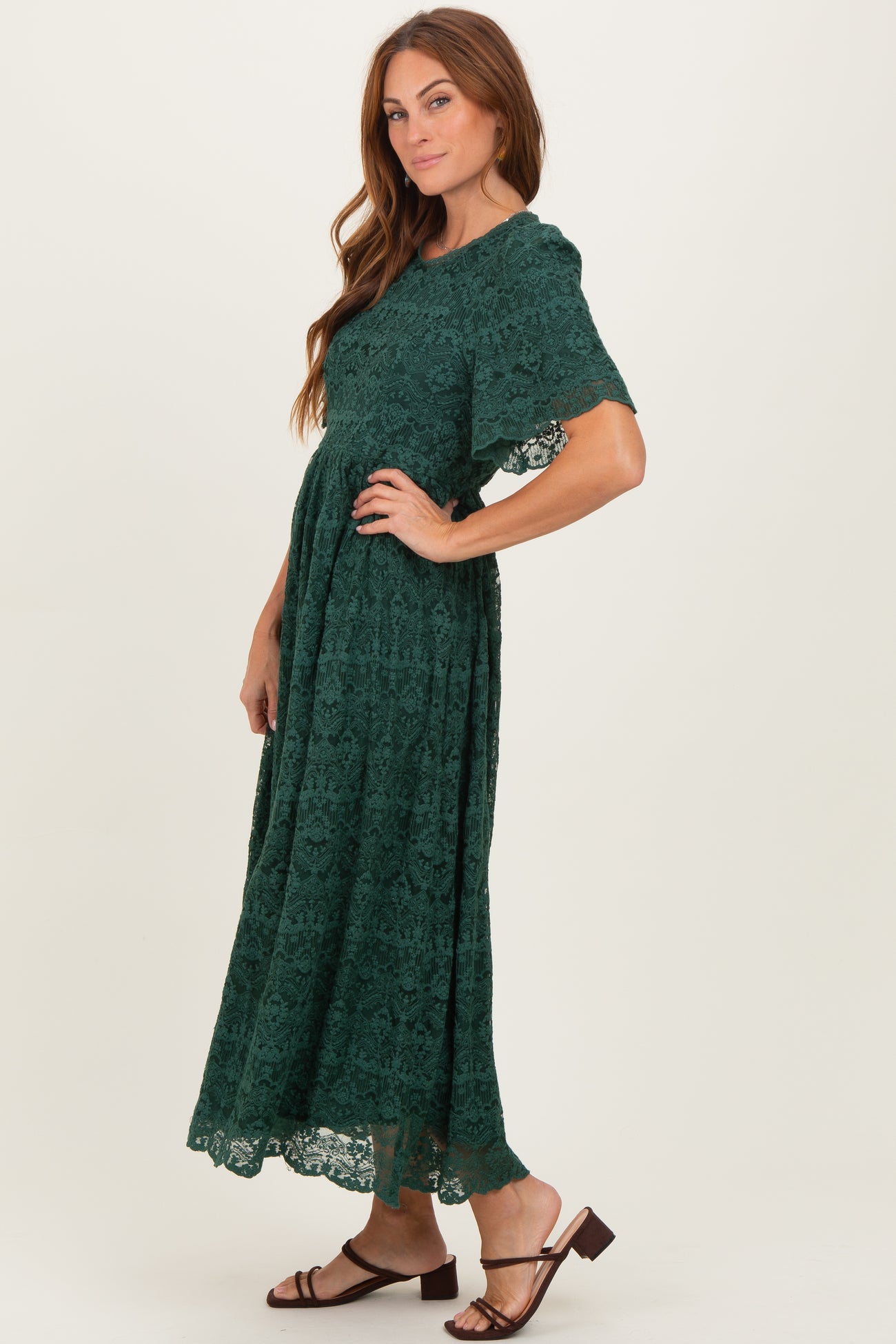 woman wearing a dark green lace maxi dress with short sleeves and a flowing silhouette