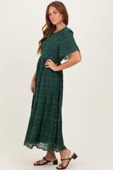 woman wearing a dark green lace maxi dress with short sleeves and a flowing silhouette