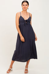 woman wearing a navy blue maxi dress with a front tie detail and thin straps