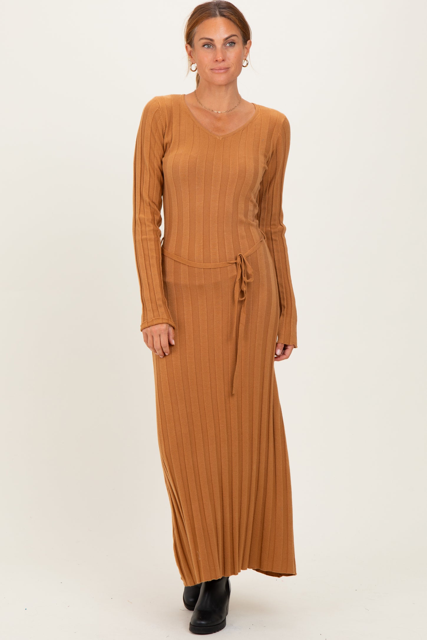 woman wearing a long caramel ribbed maxi dress with a v-neck and drawstring waist