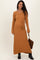 woman wearing a mustard ribbed maternity sweater dress with a tie waist and long sleeves, holding a handbag