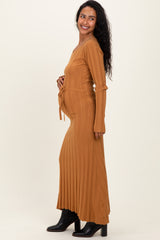 woman wearing a ribbed mustard long sleeve maternity dress, styled with a tie at the waist and showing her baby bump