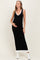 woman wearing a black maternity maxi dress with a white neckline and hem, showcasing her baby bump