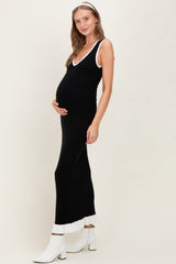 woman wearing a black maternity dress with white trim and ruffled hem, showing her baby bump