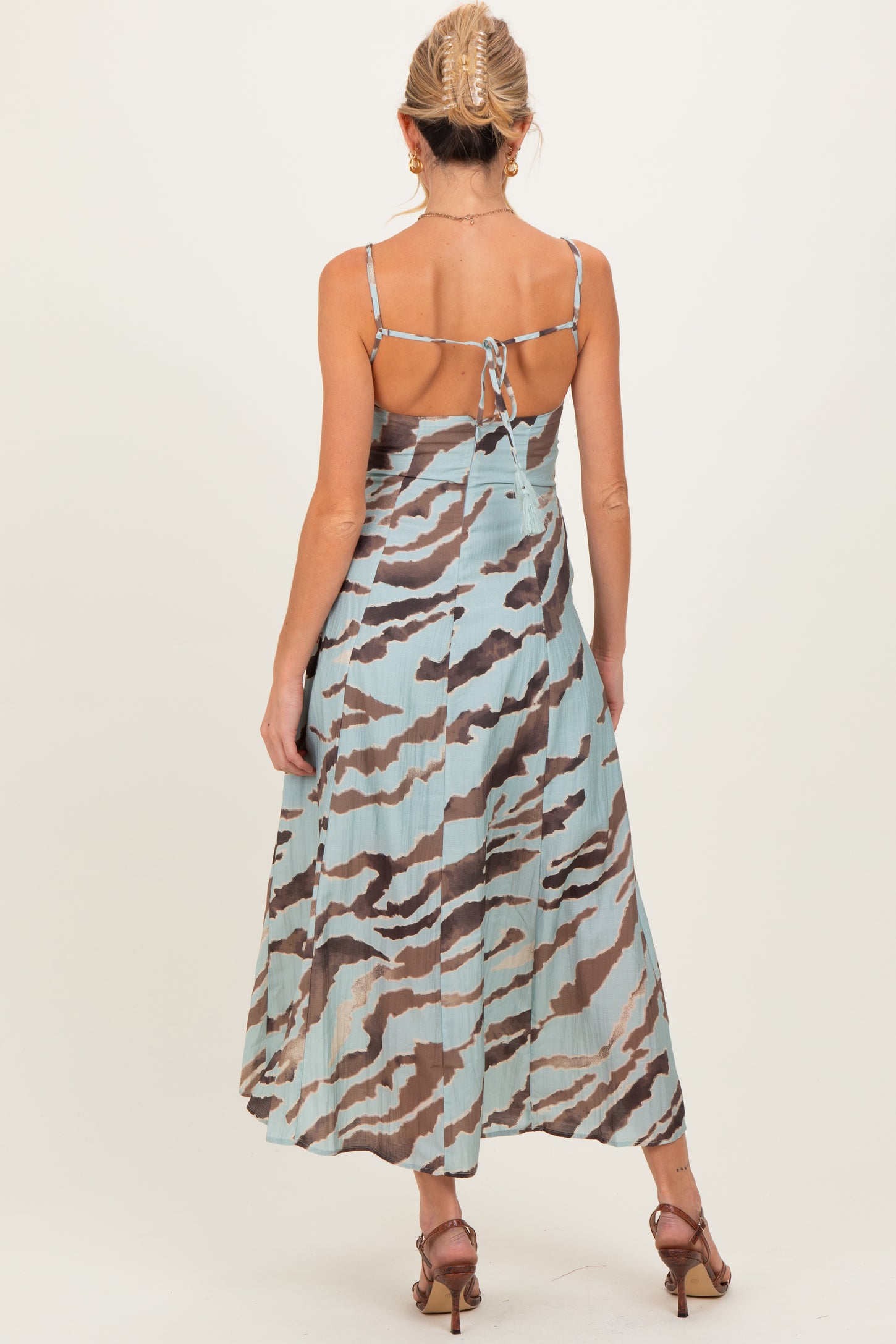 woman wearing a blue and brown striped backless maternity dress with adjustable straps