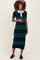 woman wearing a navy and green striped maternity dress with a white collar and holding her baby bump