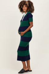 woman wearing a navy and green striped short sleeve maternity dress, cradling her baby bump