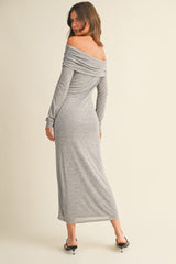 woman wearing a gray off-the-shoulder maxi dress, showing a fitted silhouette and long sleeves