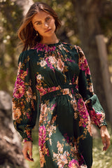 woman wearing a dark green floral maxi dress with puff sleeves and a cinched waist
