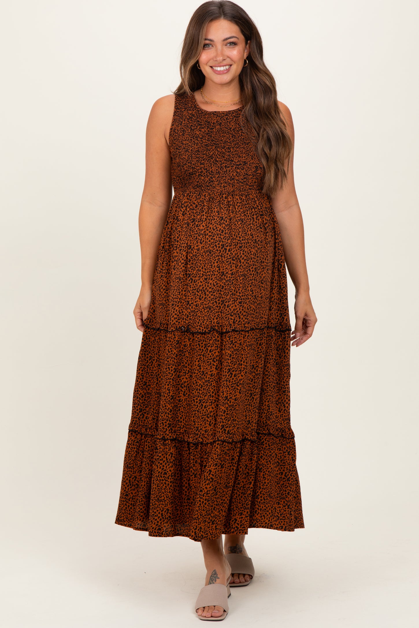 woman wearing an orange and brown leopard print maternity maxi dress with tiered layers and a fitted bodice