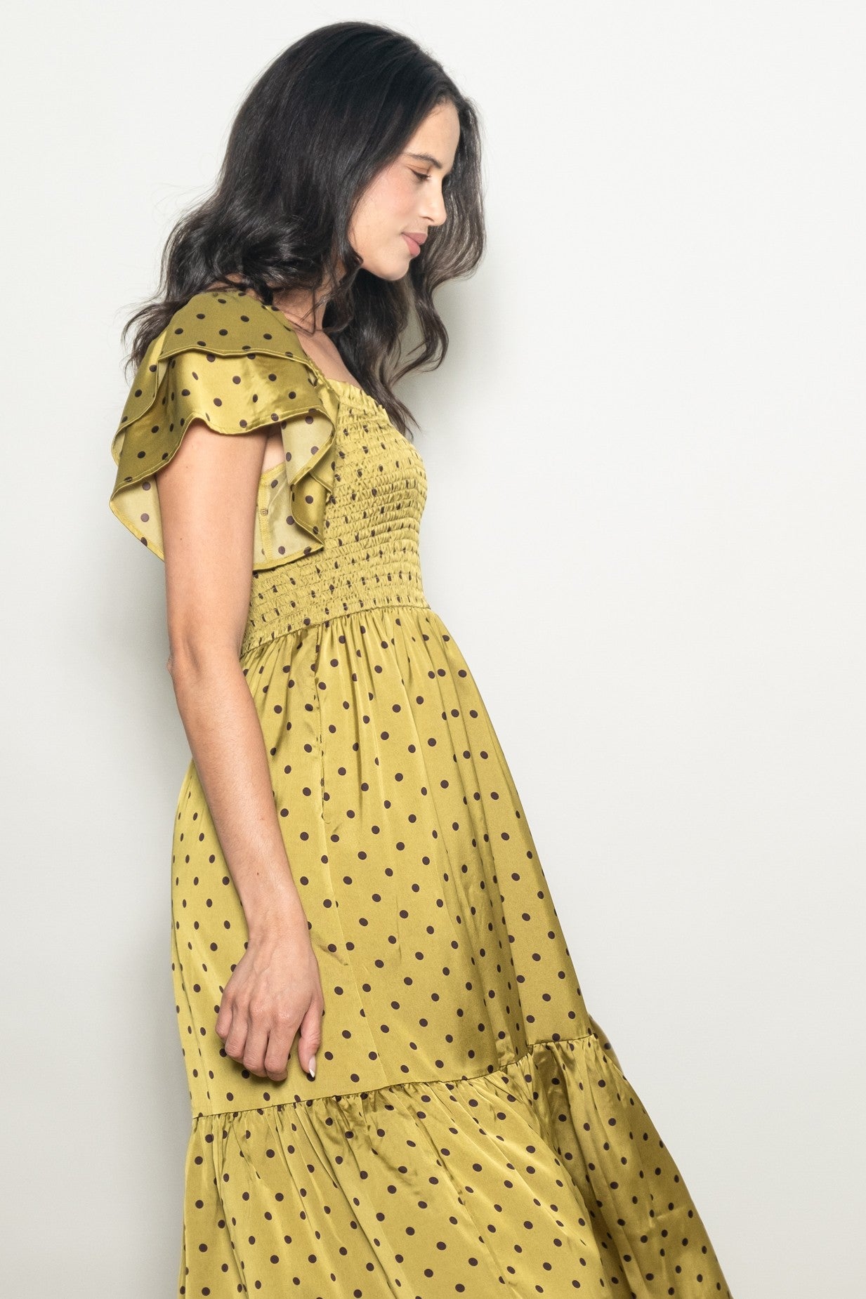 woman wearing a yellow polka dot maxi dress with ruffled sleeves and a smocked bodice
