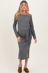 woman wearing a gray and white striped maternity dress with a tied waist and side slit, showcasing her baby bump