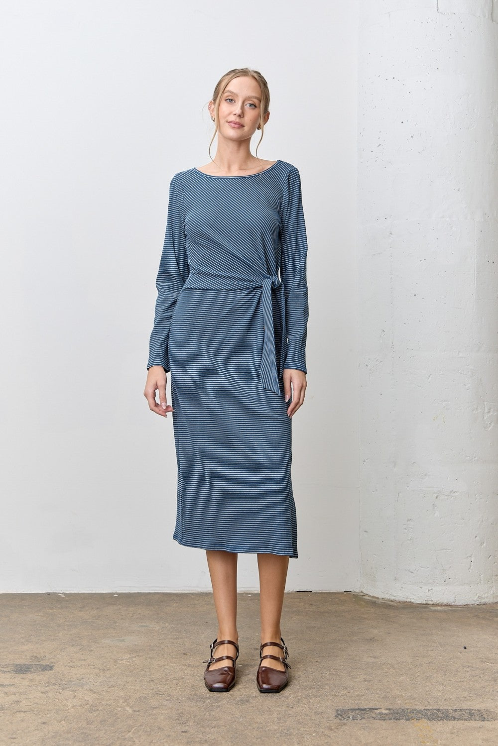 woman wearing a blue striped long sleeve dress with a tie waist detail