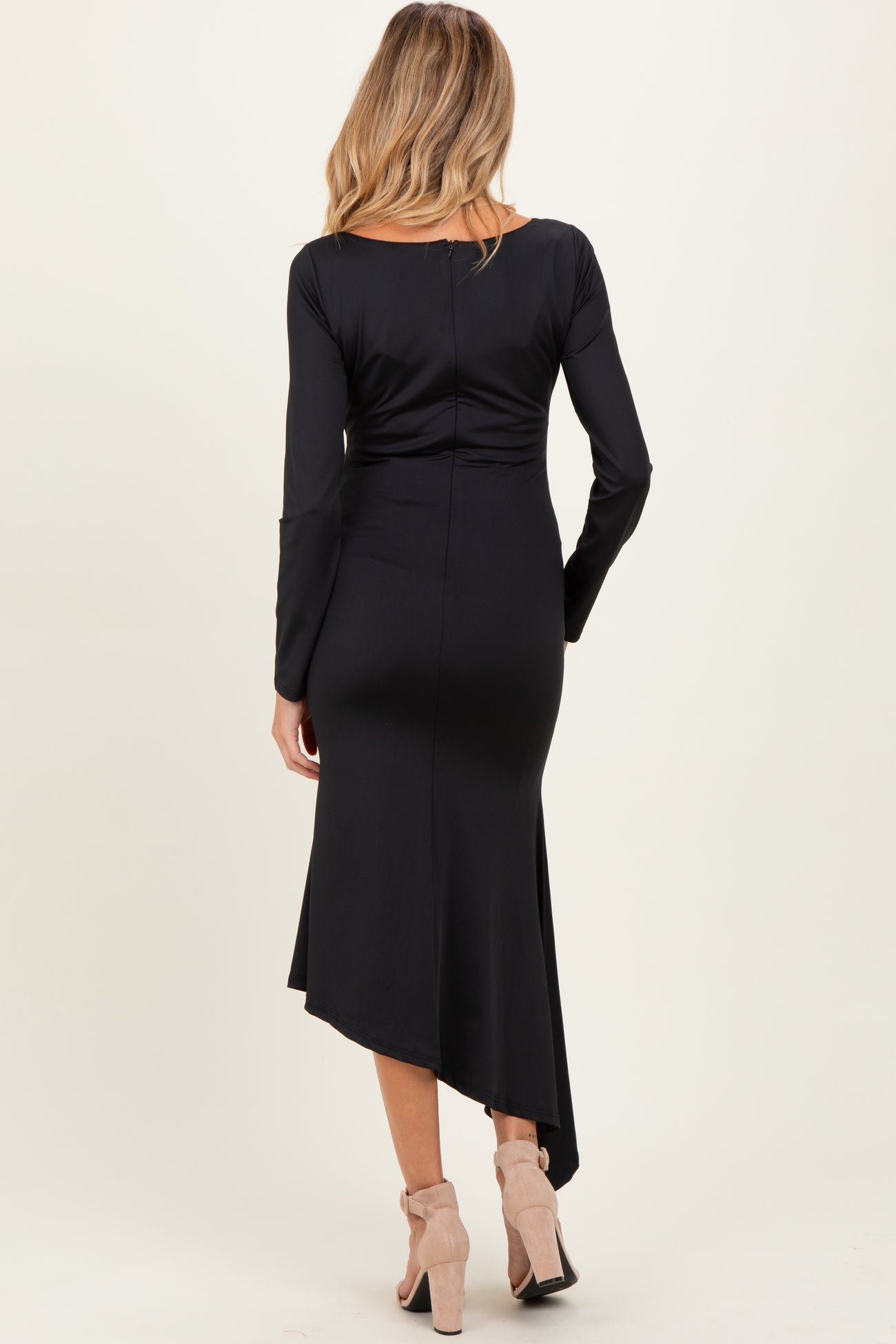 woman wearing a black long sleeve maternity dress with an asymmetrical hem and a form-fitting silhouette