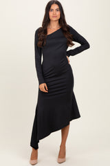 woman wearing a black long sleeve asymmetrical hem dress and beige high heels