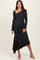 woman wearing a black one-shoulder long sleeve dress with an asymmetric hem and heels