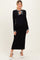 woman wearing a black ribbed maternity dress with a tie neckline and white stripe details, showcasing her baby bump