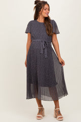 woman wearing a navy blue floral print maternity dress with short sleeves and a tie at the waist