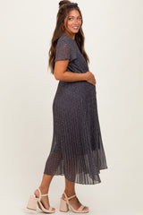 woman wearing a navy floral midi maternity dress with short sleeves and a pleated skirt, showcasing her baby bump