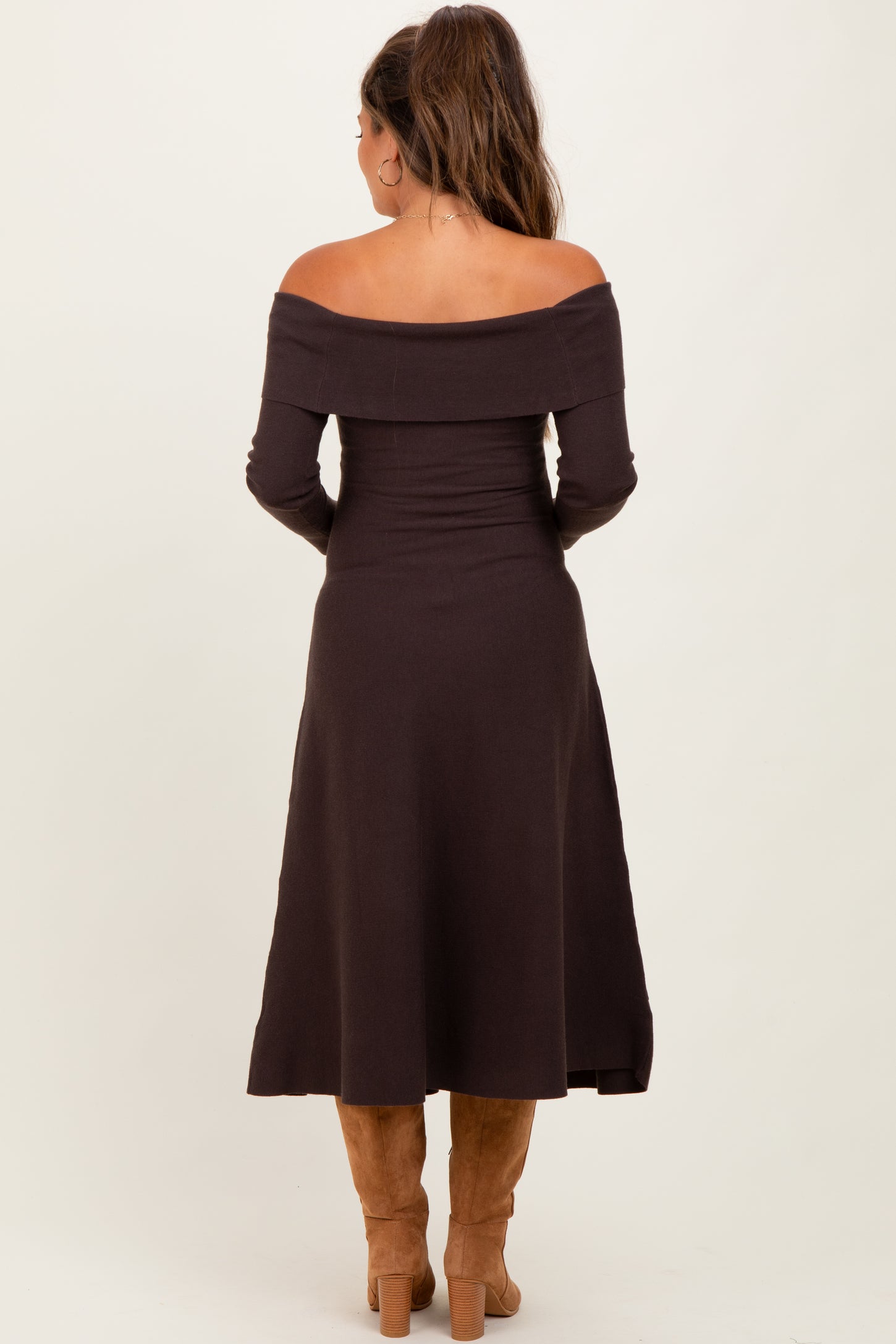 woman wearing a chocolate brown off-shoulder maternity dress, shown from the back, with a fitted bodice and flared skirt