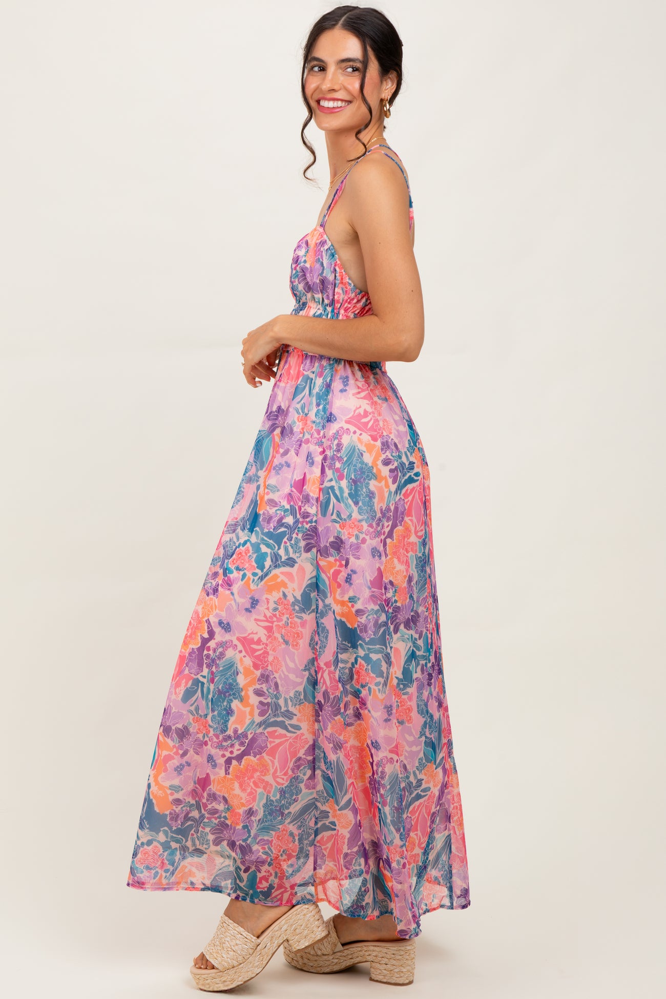 woman wearing a colorful floral maxi dress with spaghetti straps and wedge sandals