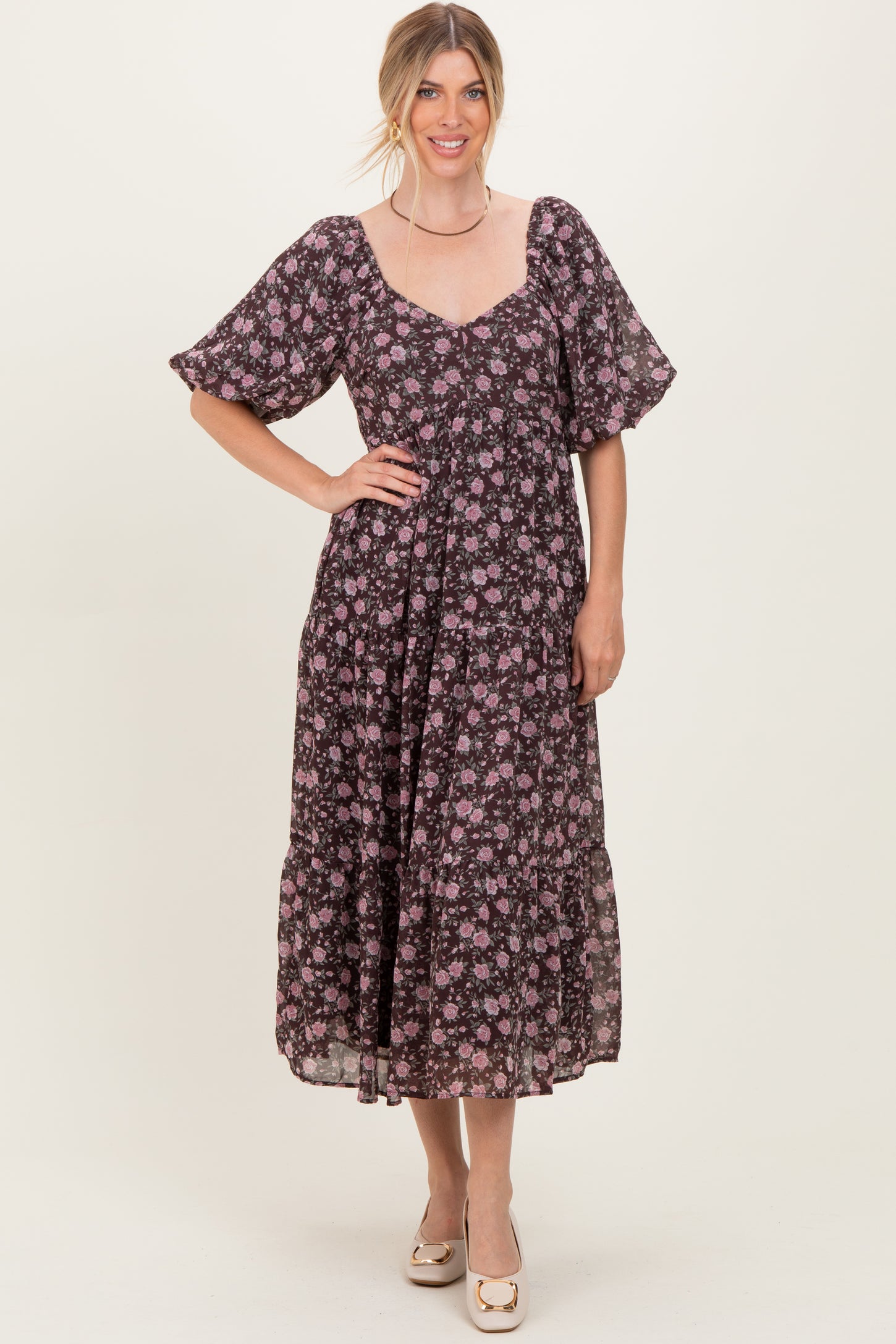 woman wearing a dark floral midi dress with short puff sleeves and a square neckline