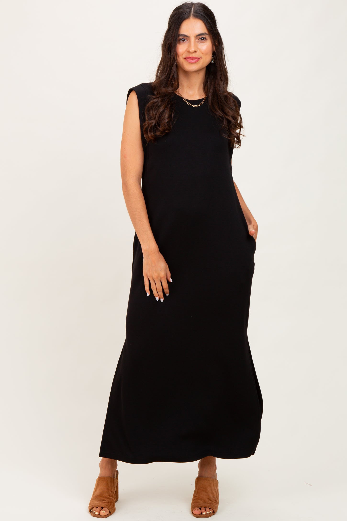woman wearing a black sleeveless maxi dress with pockets and a relaxed fit