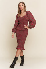 woman wearing a red checkered fitted dress with puffed sleeves and a ruffled hem, paired with black ankle boots