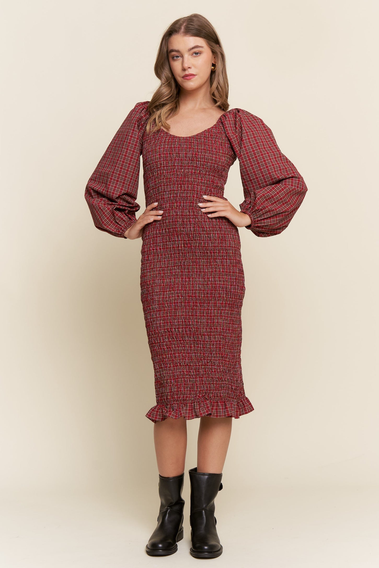 woman wearing a red and black patterned puff sleeve midi dress with a fitted bodice and ruffled hemline