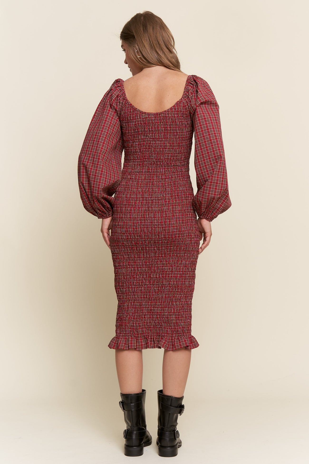 woman wearing a maroon smocked midi dress with puff sleeves and ruffled hem, seen from the back