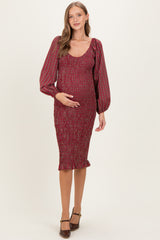 woman wearing a red checkered maternity dress with puffed sleeves and a fitted silhouette, highlighting her baby bump