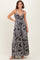 woman wearing a black and white patterned maxi dress with adjustable straps and a drawstring waist
