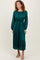 woman wearing a dark green midi dress with pleated skirt and long sleeves, styled with open-toe heels