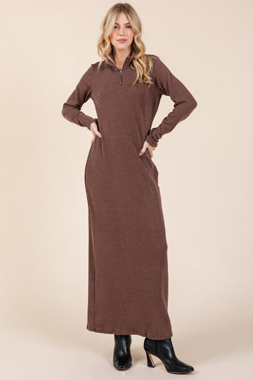 woman wearing a brown striped long sleeve maxi dress with a zip collar and side pockets