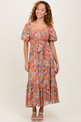 woman wearing a floral off-the-shoulder maxi dress with puff sleeves and a cinched waist