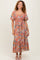 woman wearing a floral off-the-shoulder maxi dress with puff sleeves and a cinched waist