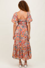woman wearing a floral midi dress with puff sleeves and a smocked bodice, shown from the back